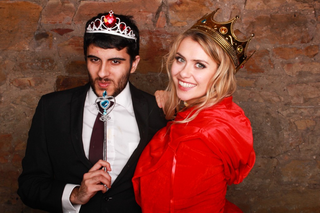 Man with tiara and women with crown in photo booth