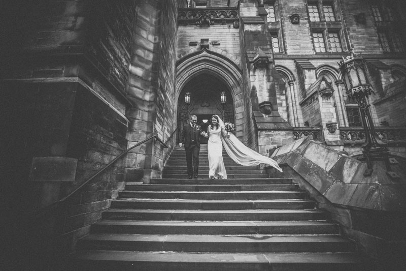 Bride & Groom walk down steps after ceremony at Glasgow University Memorial Chapel