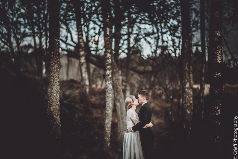 Bride and groom embrace in woodlands at Comrie Croft wedding